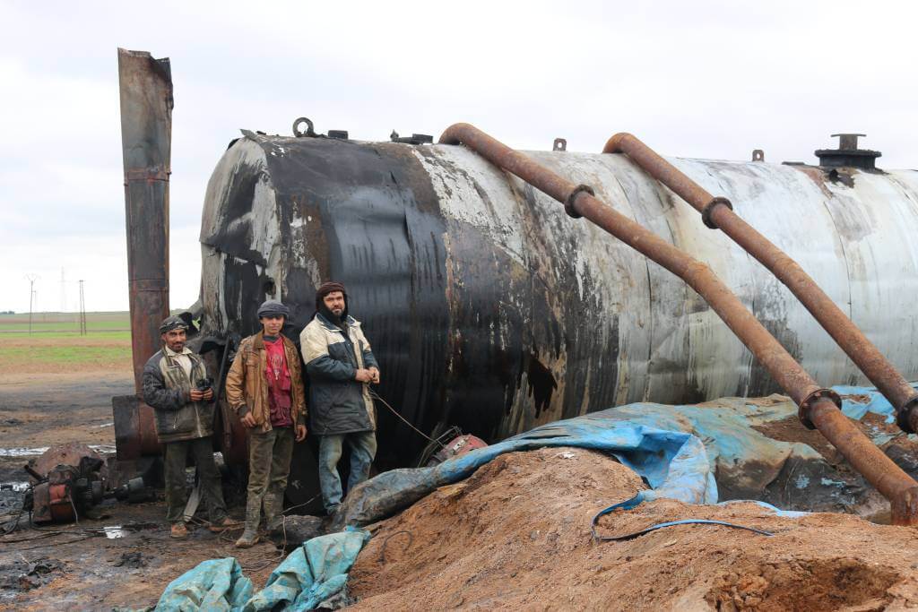 ” Children working at an oil burner used for makeshift oil refining in Qarayah, north east Syria. November 30, 2018. Copyright Wim Zwijnenburg” ©Wim Zwijnenburg ⁃ Wim Zwijnenburg